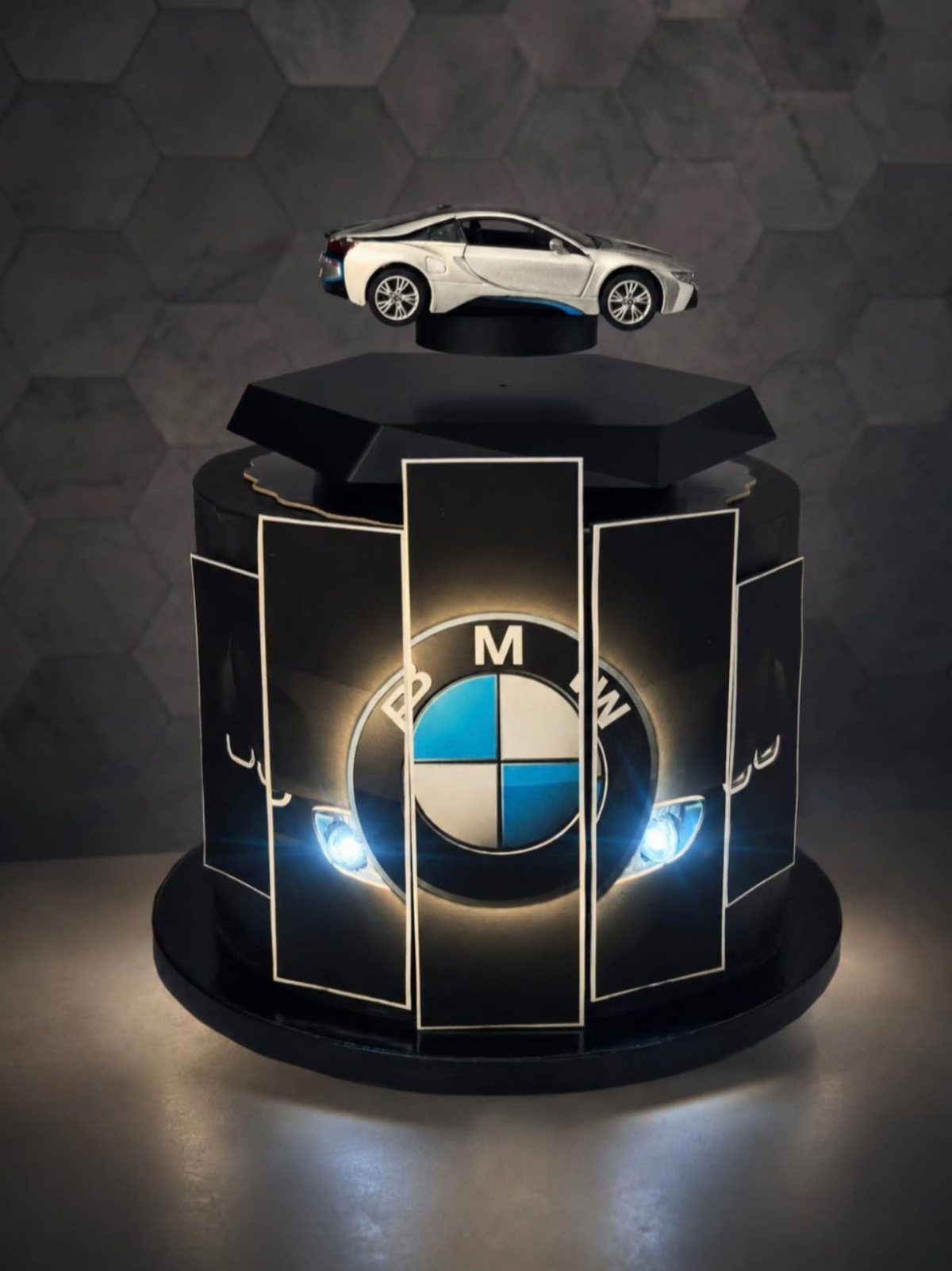 3D sports car cake with a white car model and BMW logo.