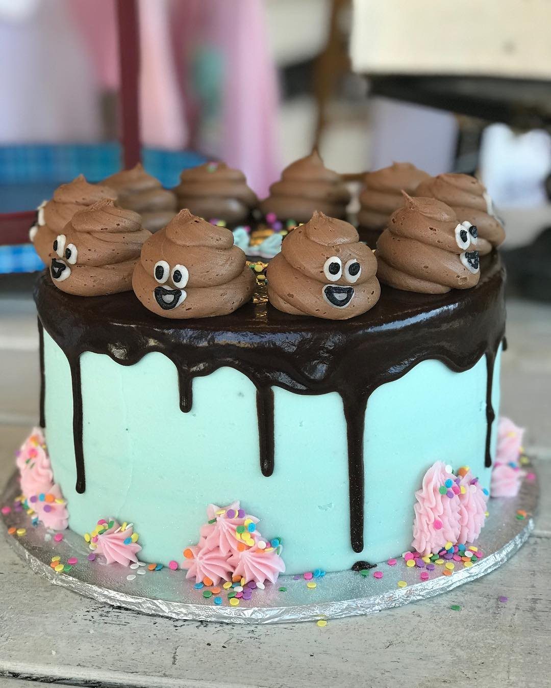 Funny emoji cake with chocolate frosting and colorful decorations.
