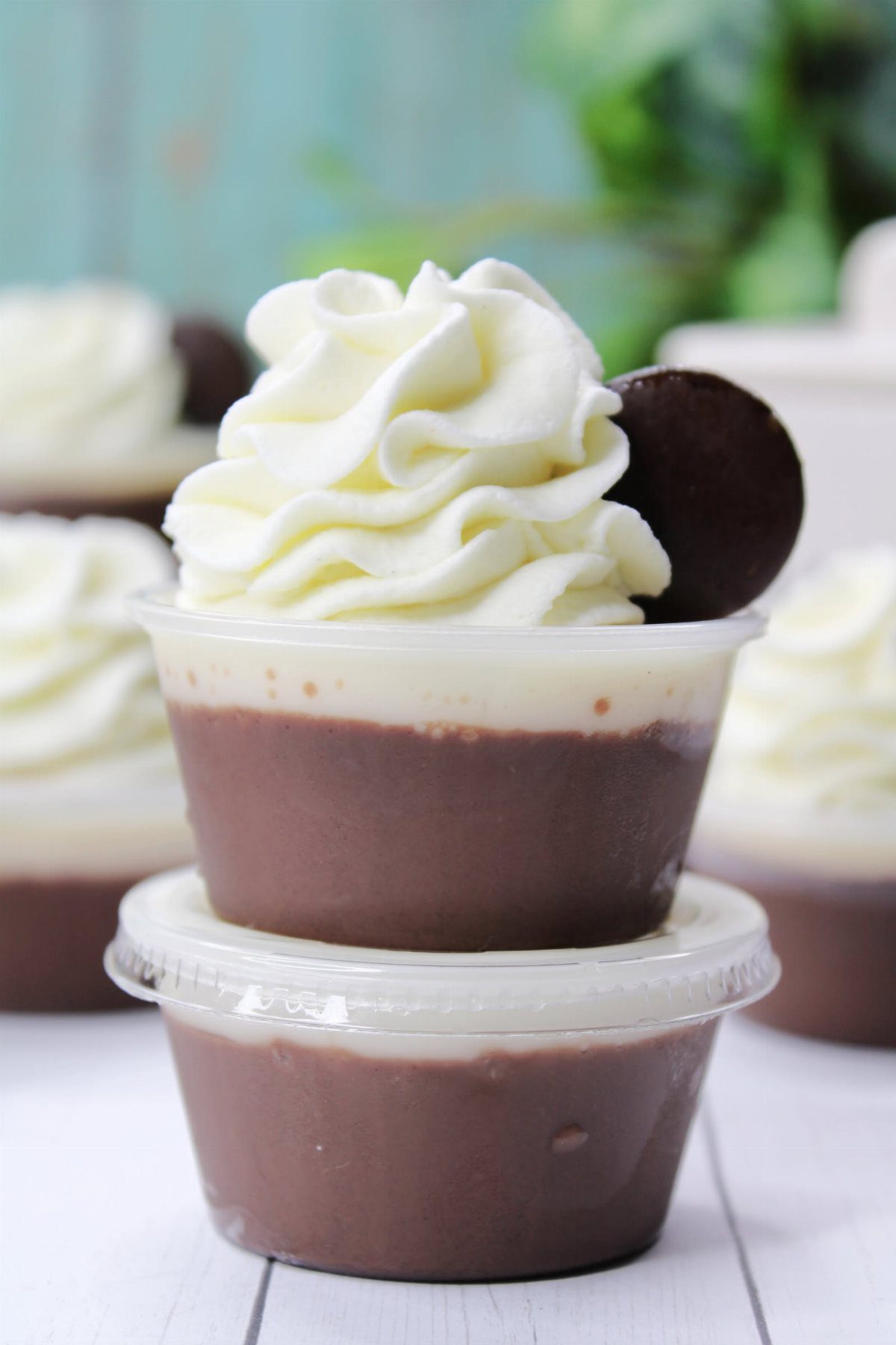 Chocolate mousse cups topped with whipped cream and a cookie.