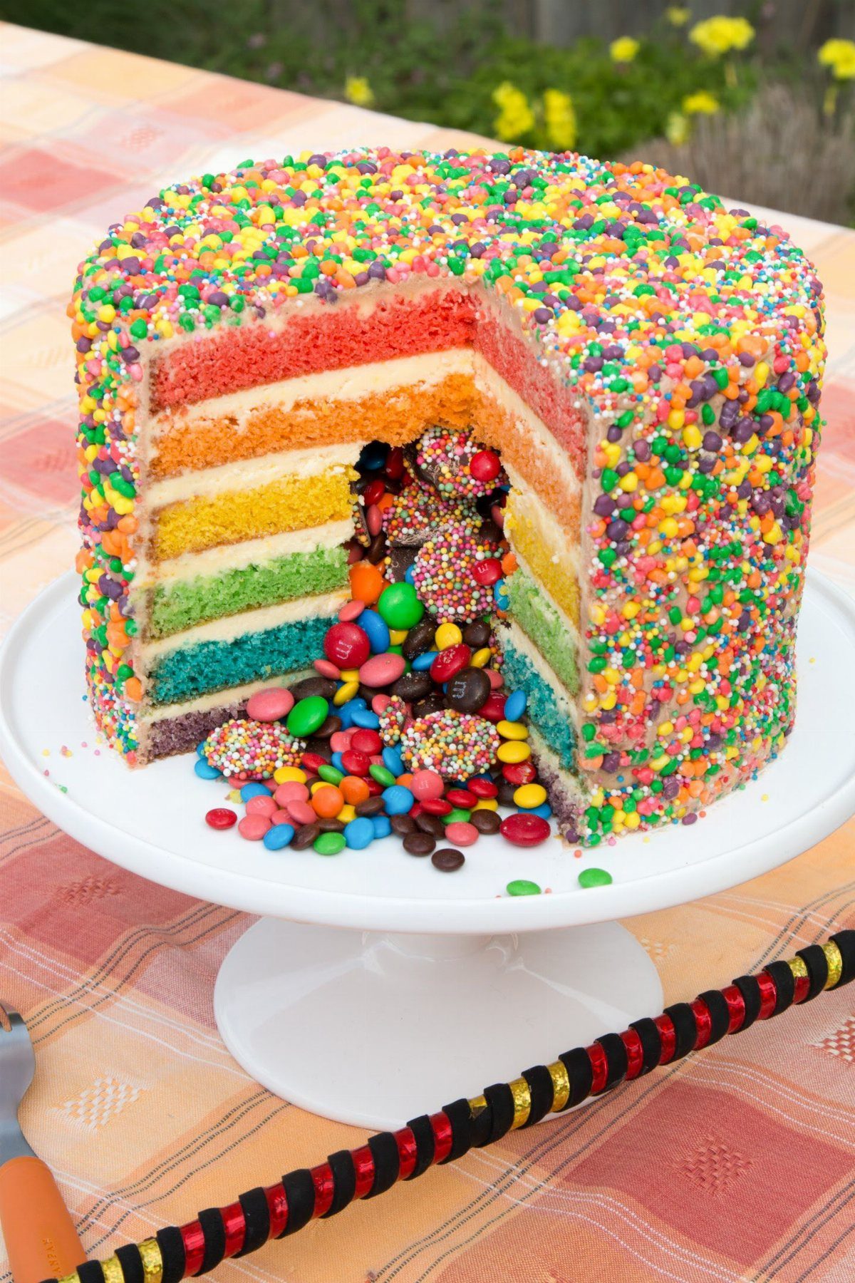 Rainbow layer cake with colorful layers and candy inside.