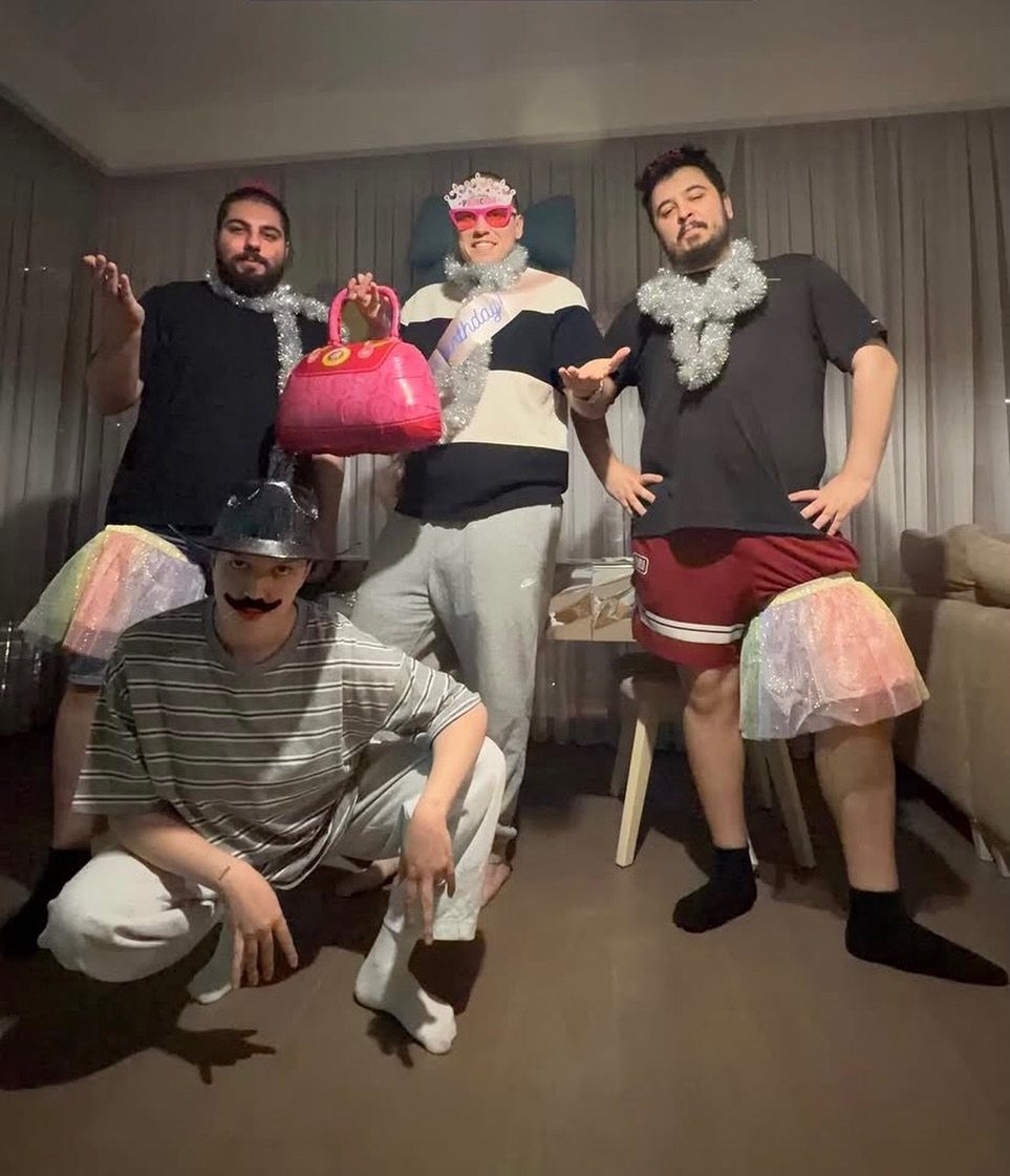 Four friends in funny costumes posing together in a room.