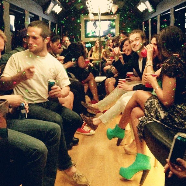 Party bus interior filled with people enjoying drinks and a festive atmosphere.