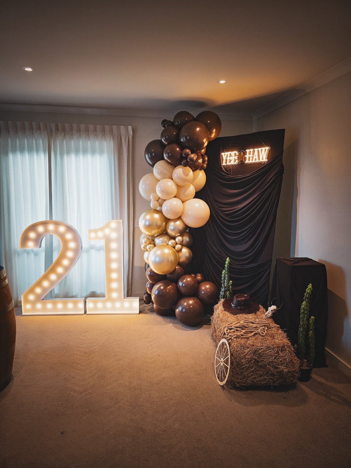 Decorated space with a large '21' sign and a balloon arch.
