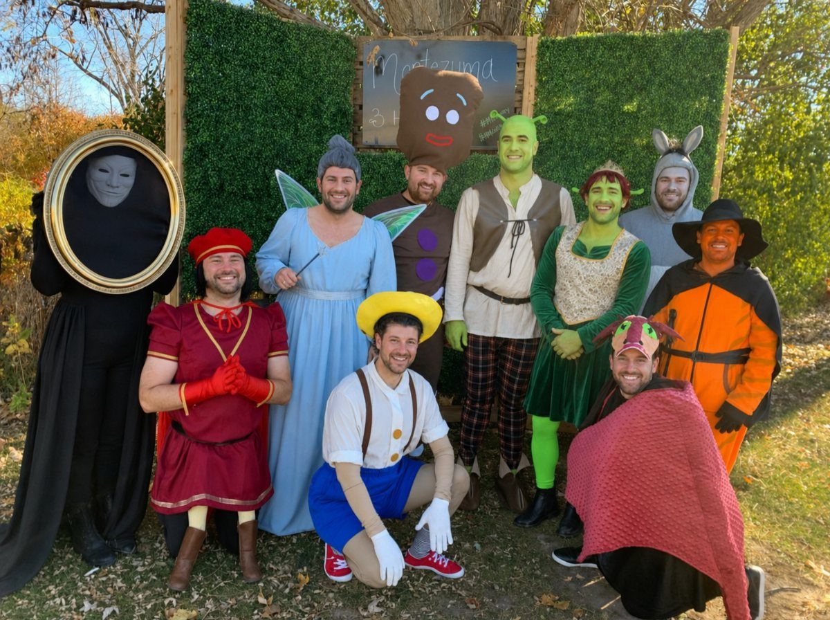 A group of friends smiling while wearing various colorful character costumes outdoors.