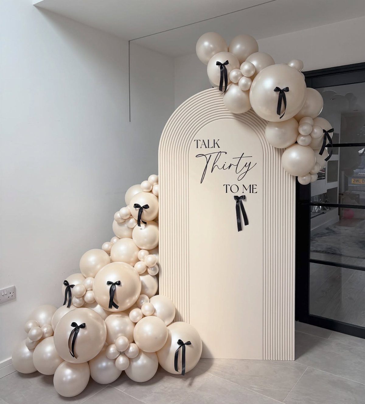 Cream arched backdrop with balloons and text reading Talk Thirty To Me.