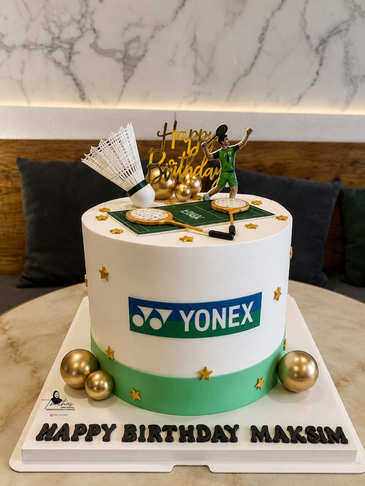 Badminton themed birthday cake with rackets, shuttlecock, and a player figurine on top.