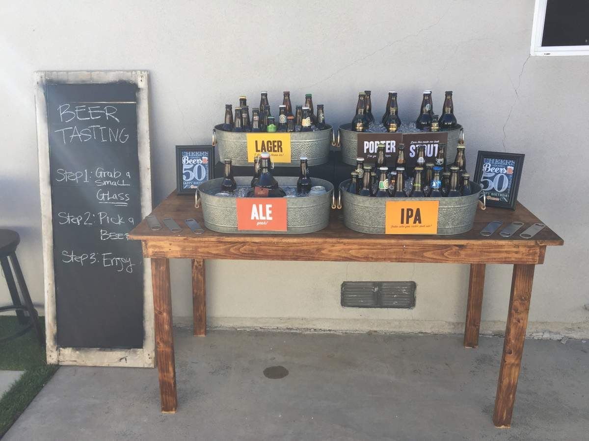 A wooden table set up for beer tasting with ice-filled tubs of various beer types.