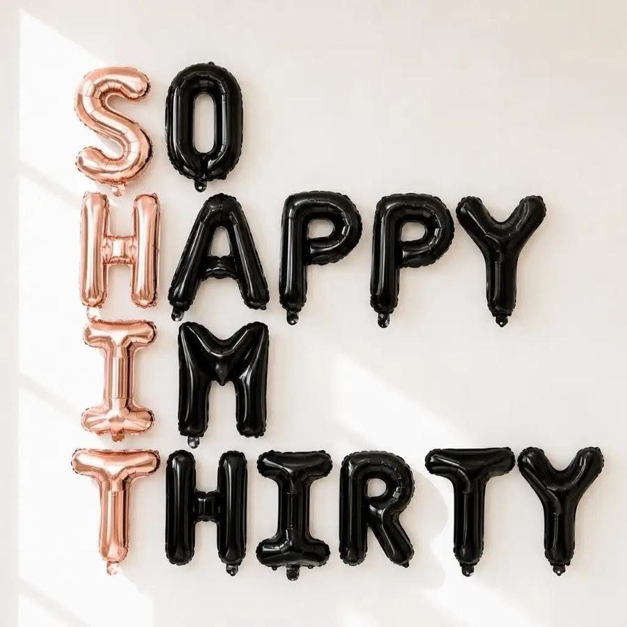 Rose gold and black foil balloons spelling out SO HIP THIRTY on a white wall.