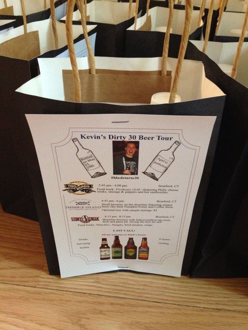 A black gift bag with a printed itinerary for a thirty birthday beer tour.