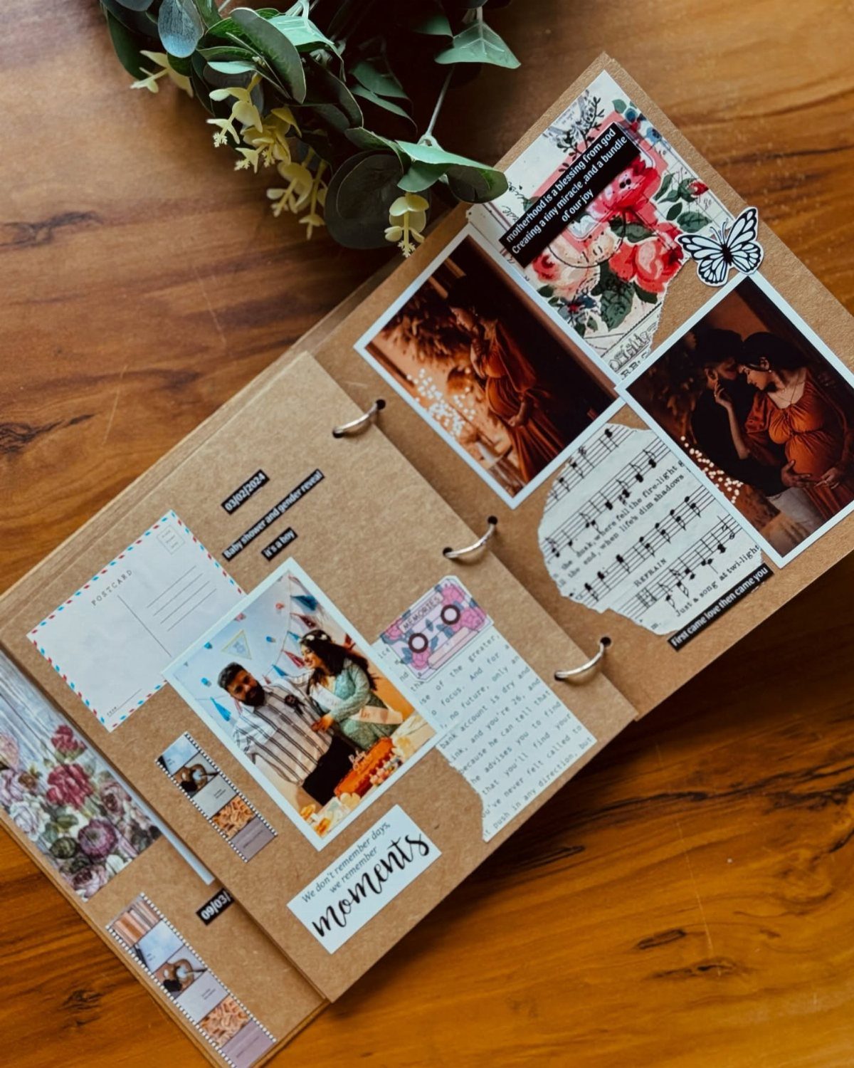 An open kraft paper scrapbook decorated with photos, flowers, and musical notes on a wooden table.