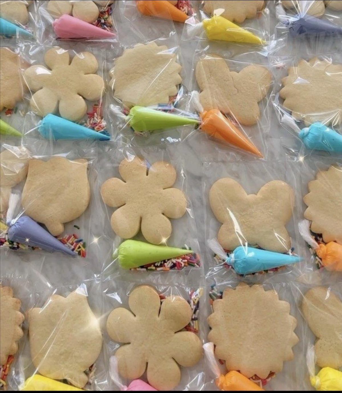Individually wrapped flower and butterfly shaped sugar cookies in clear plastic favor bags.