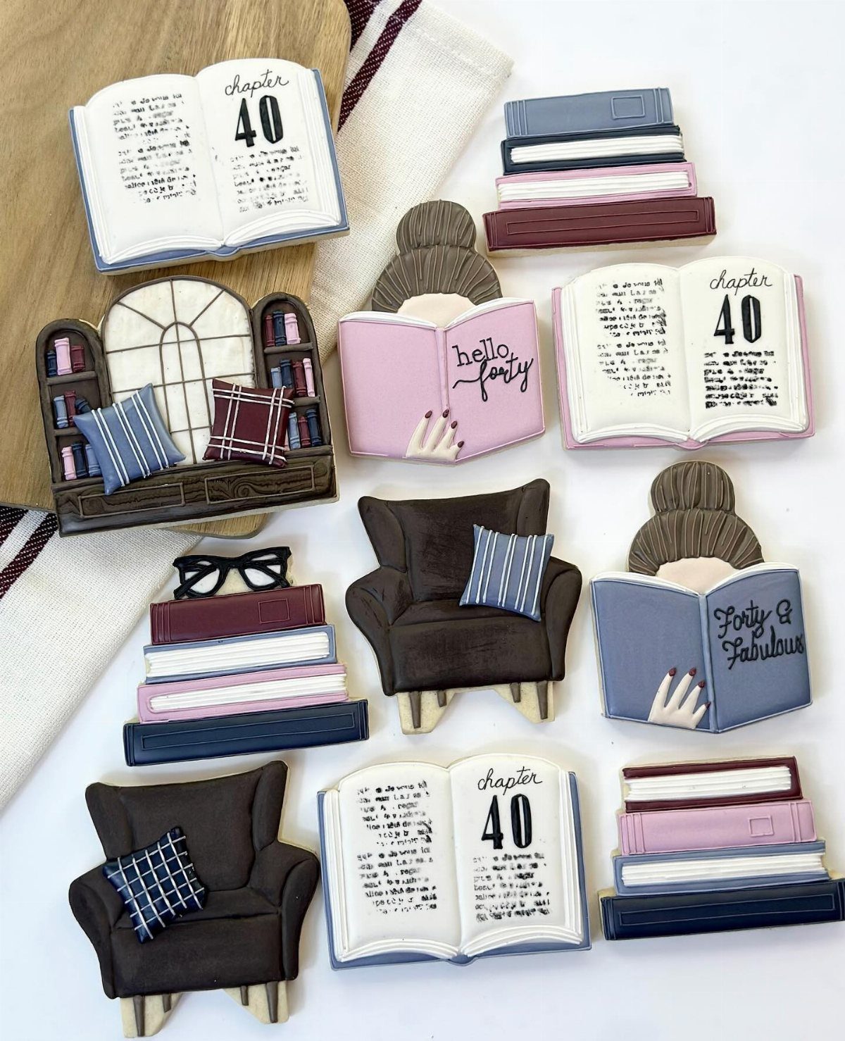 Decorated sugar cookies shaped like books, armchairs, and bookshelves in a reading theme.