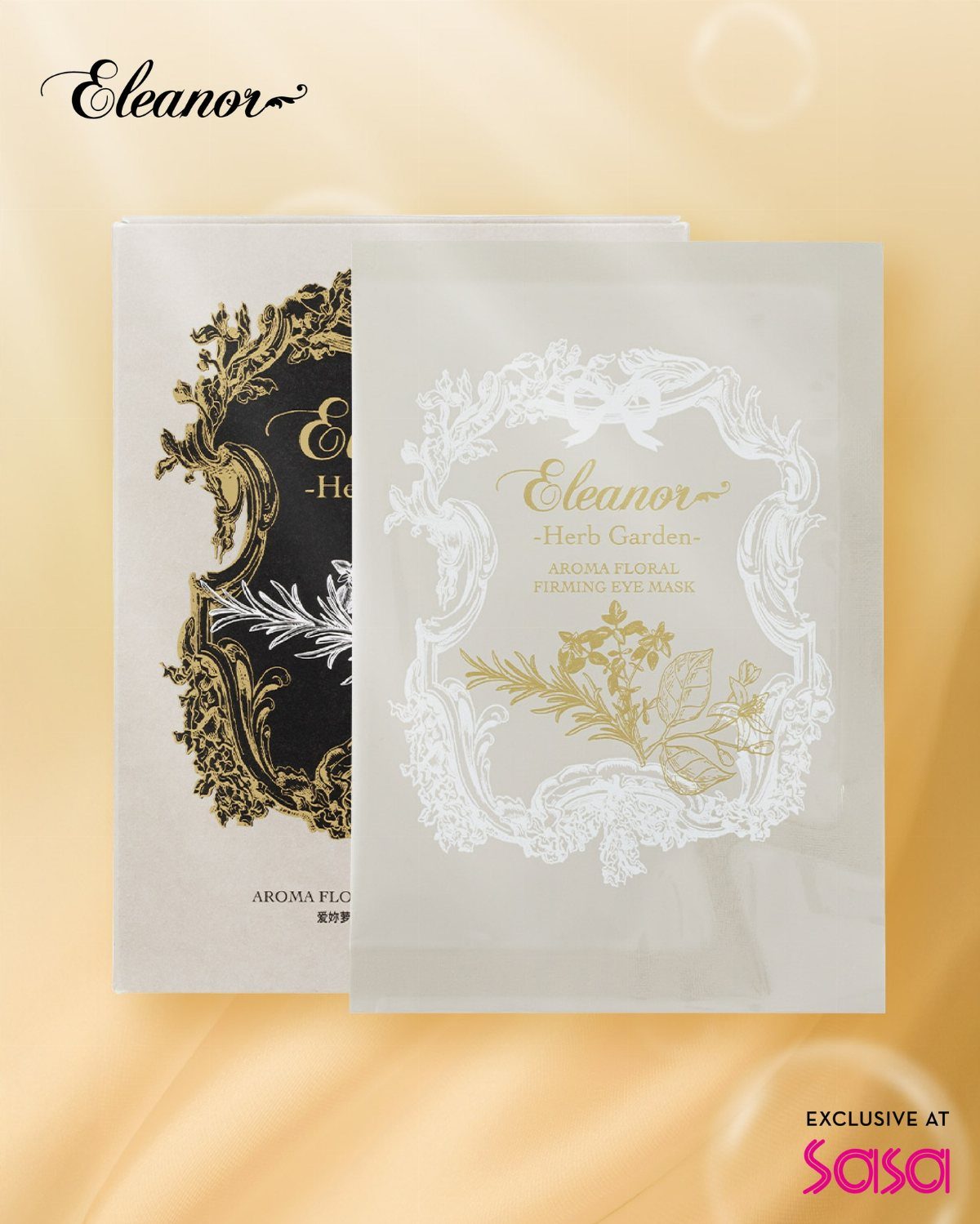 Two elegant eye mask packages with ornate botanical designs resting on golden silk fabric.