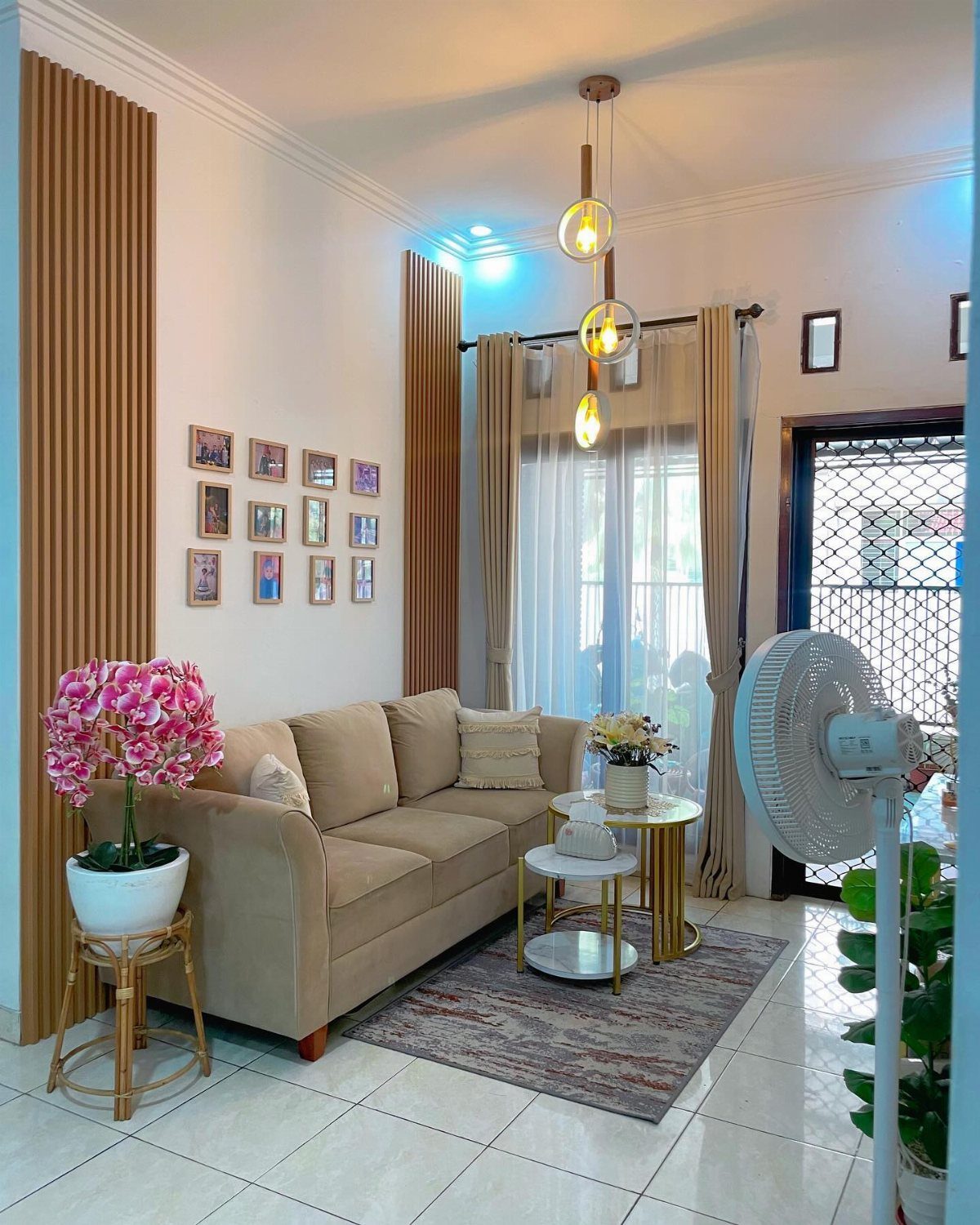 A beige sofa sits in a modern living room with gold accents and decorative wooden wall slats.