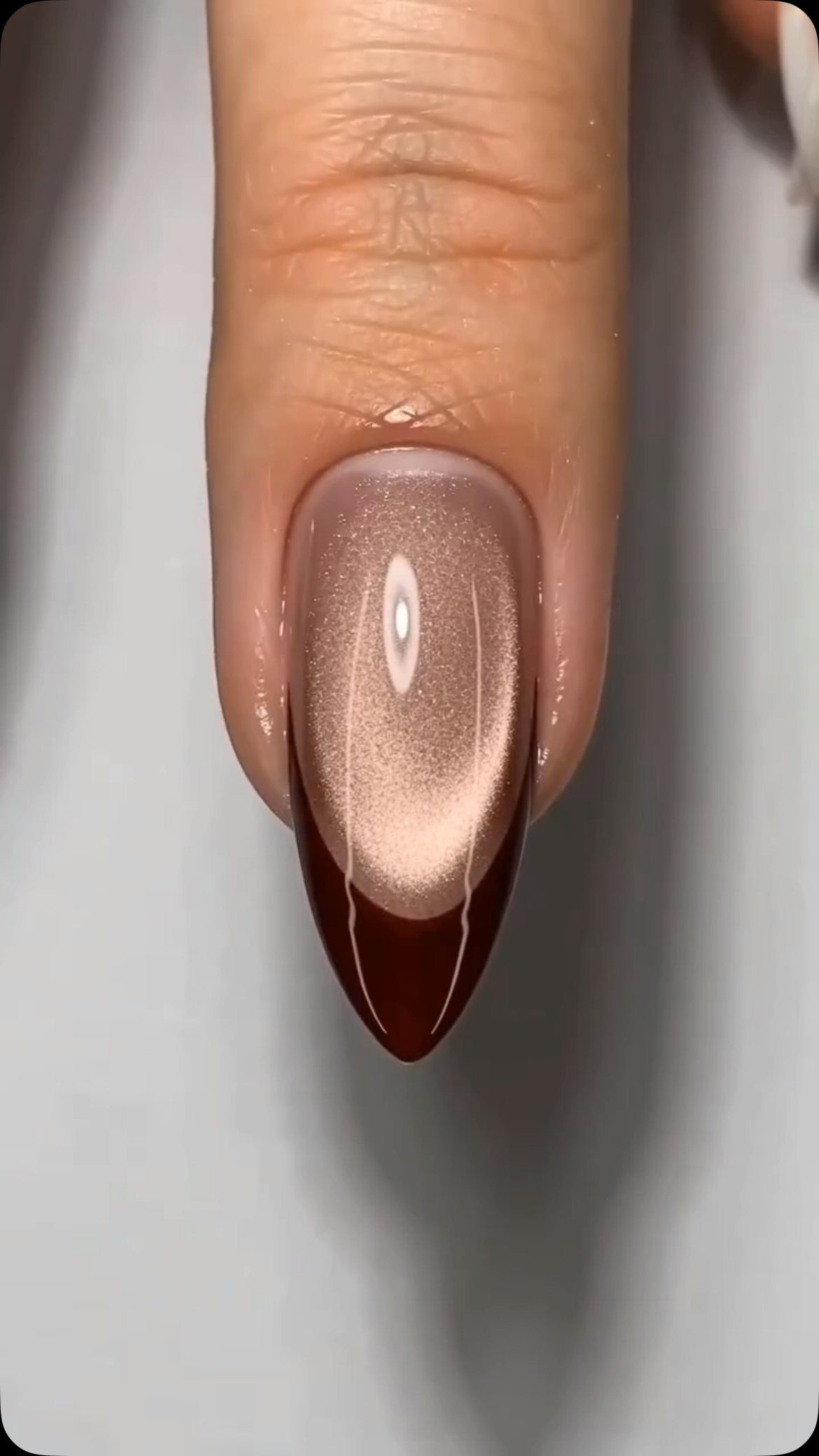 Almond-shaped nail with rose gold velvet texture and deep burgundy color.