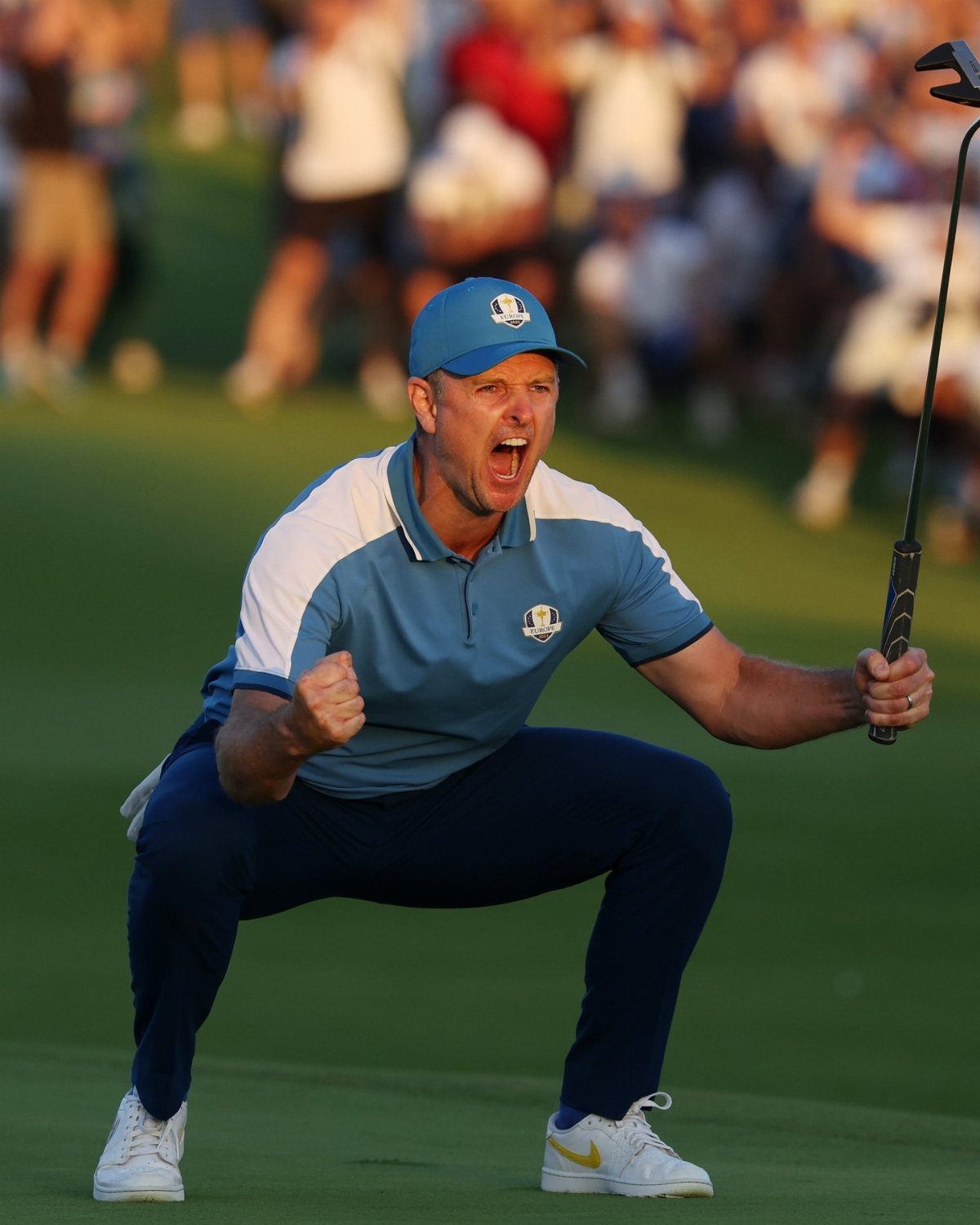 A man in golf attire celebrates enthusiastically on a green golf course.