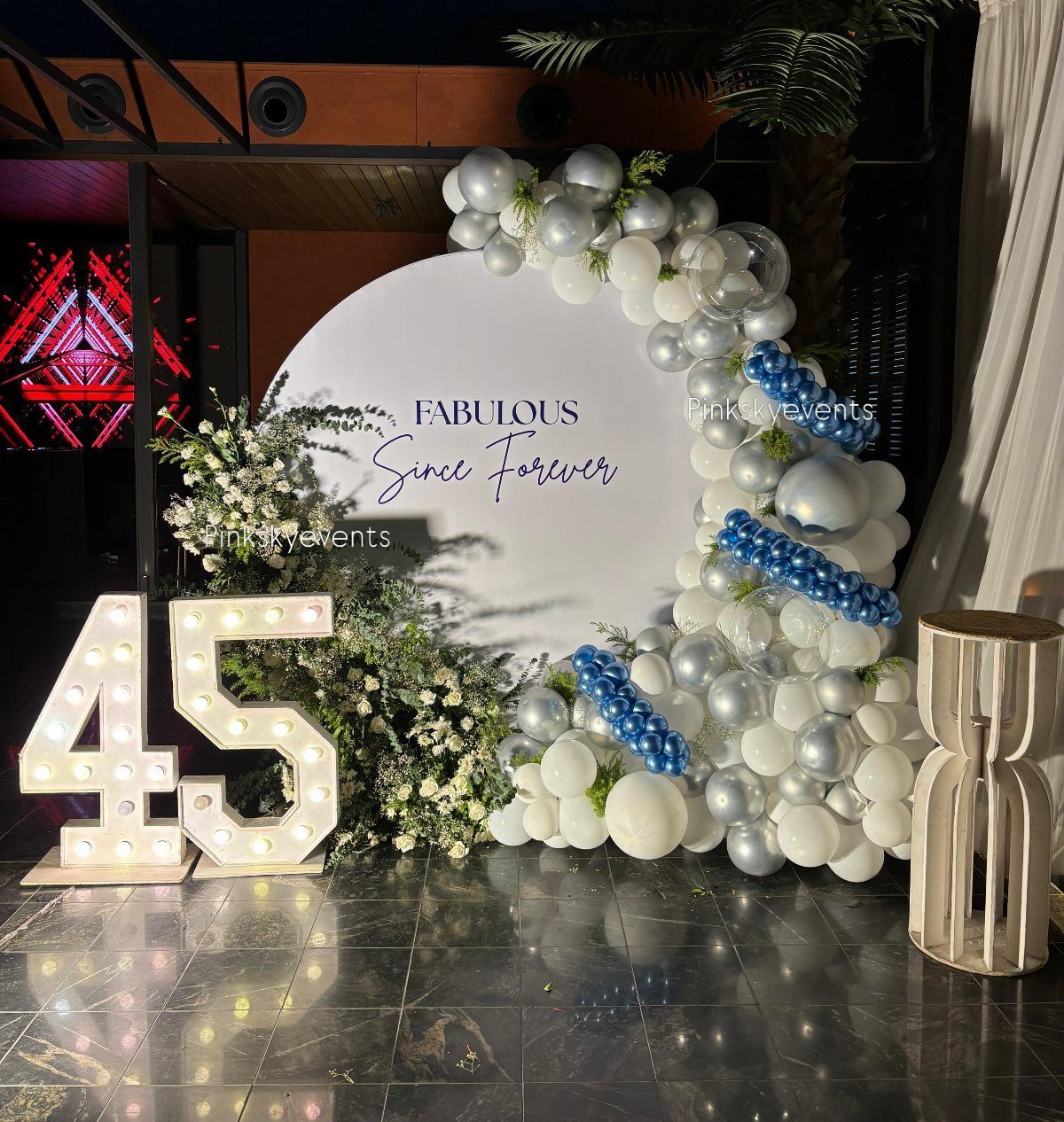 Large marquee light-up numbers 45 next to a white and blue balloon backdrop.