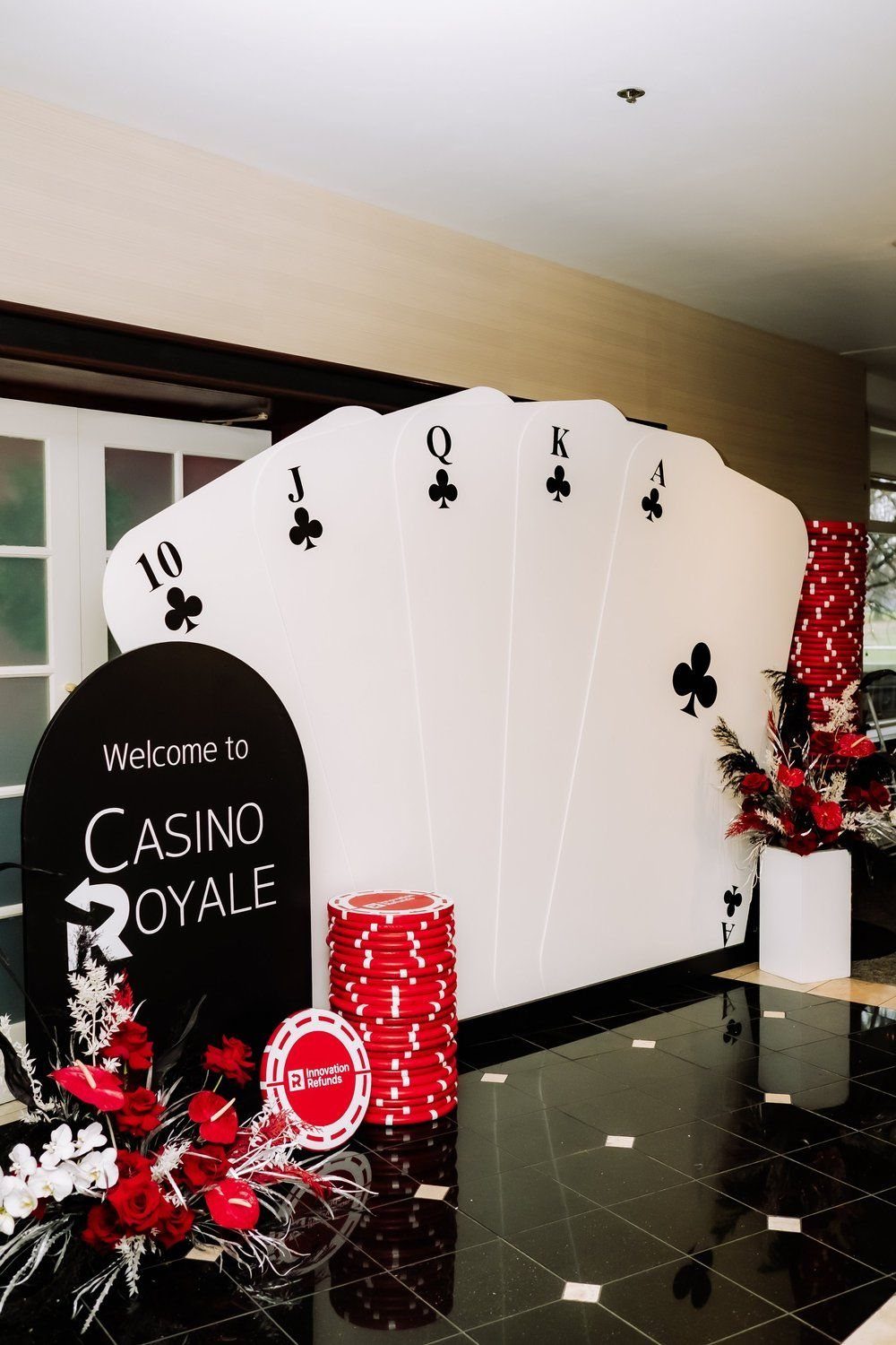 Casino themed event decorations with large playing cards, poker chips, and a welcome sign.