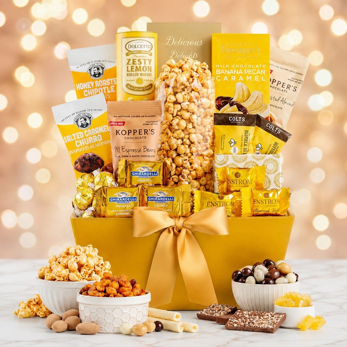 A gold gift basket filled with assorted gourmet chocolates, popcorn, and various sweet snack treats.