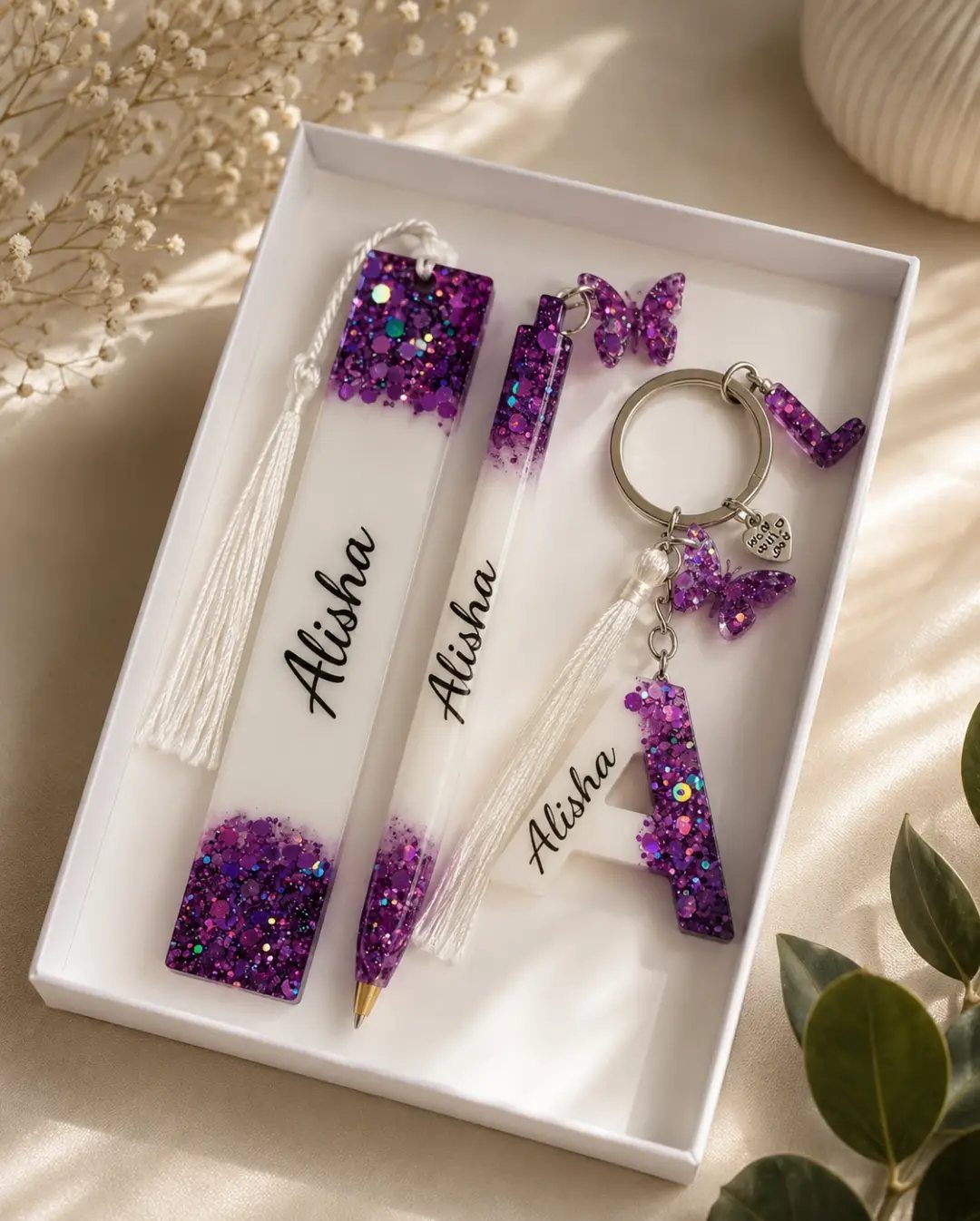 Personalized purple glitter resin bookmark, pen, and keychain set with the name Alisha.