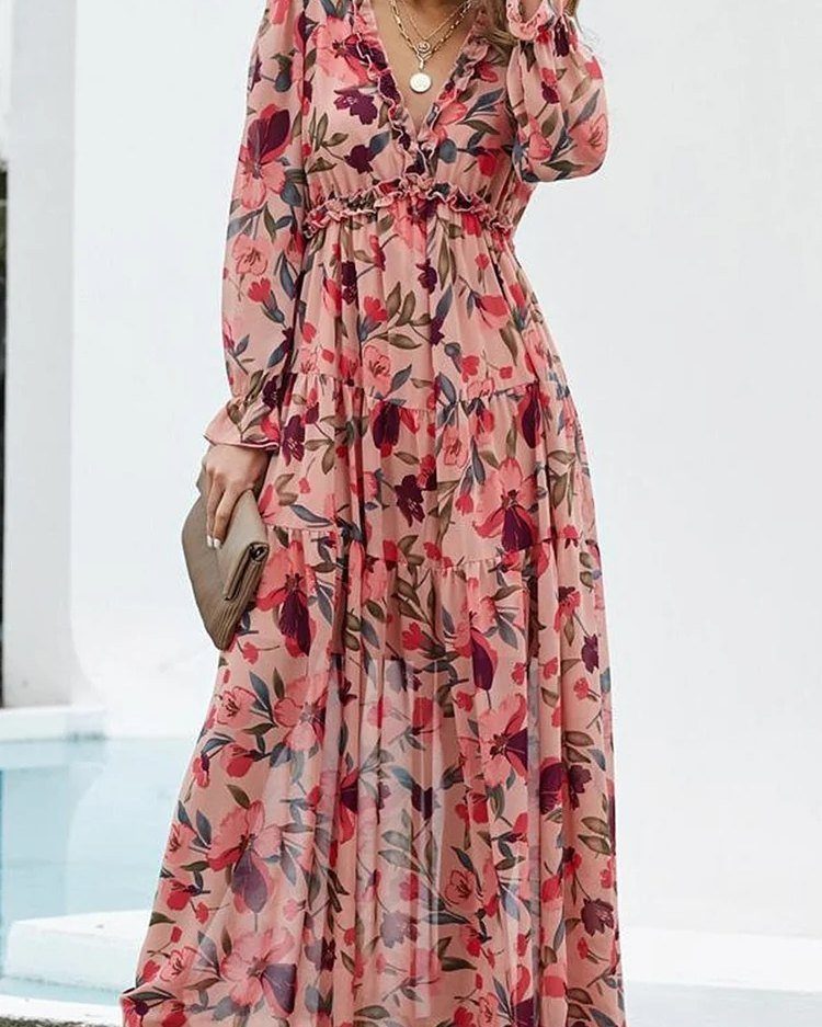 A person wearing a pink floral maxi dress and holding a tan clutch bag.