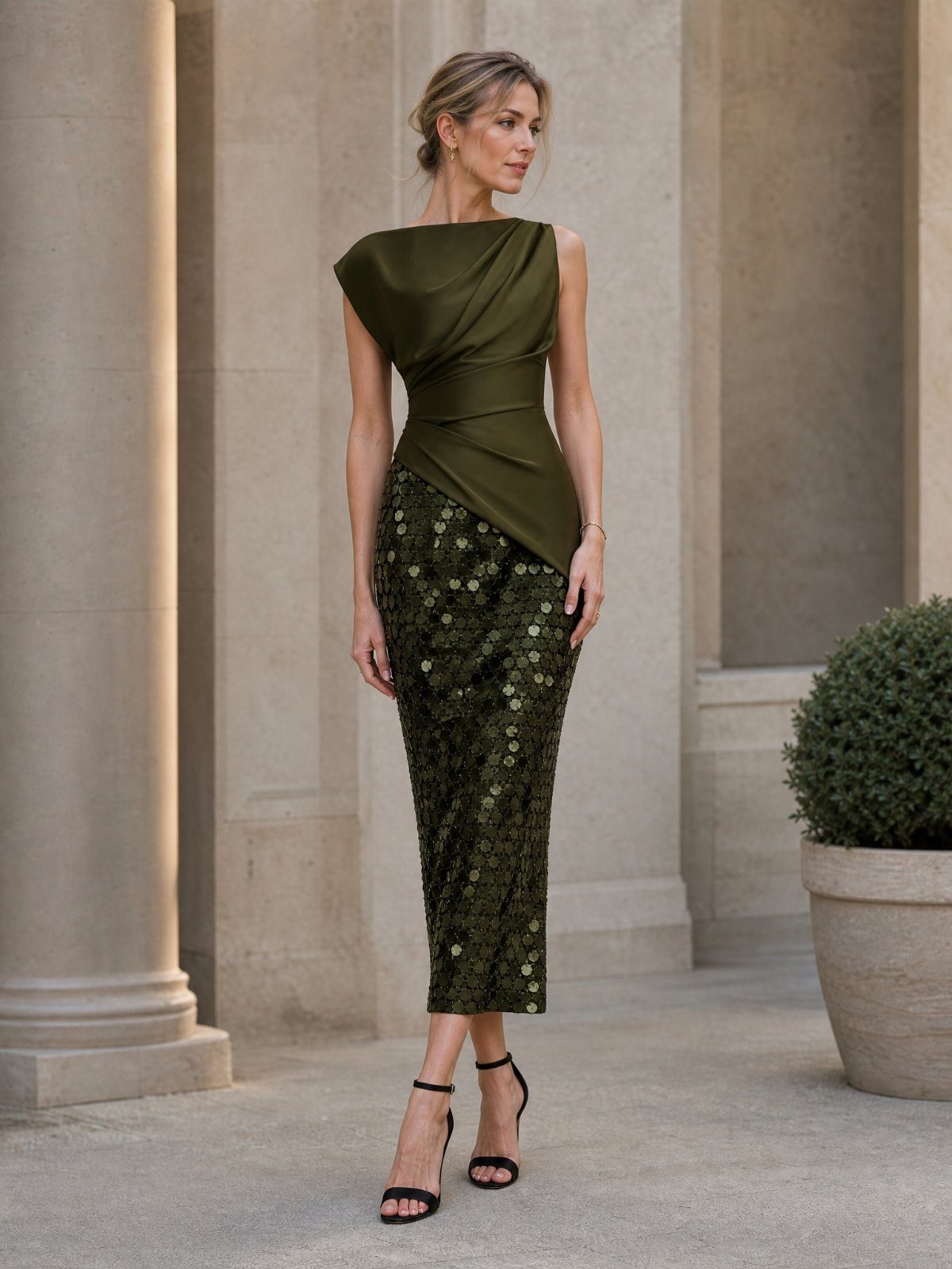 Woman in an olive green one-shoulder cocktail dress with a sequined skirt and black heels.