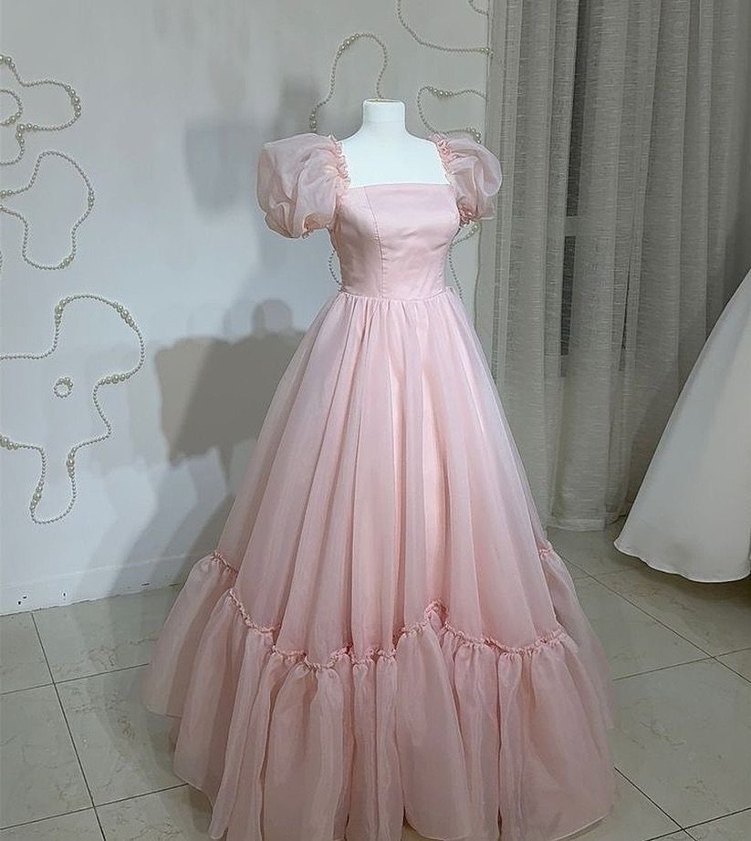 A light pink puff sleeve gown with a full tulle skirt on a mannequin.