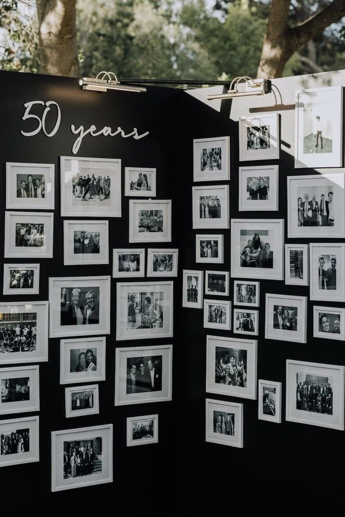 Black display board with white framed black and white photos and fifty years text.