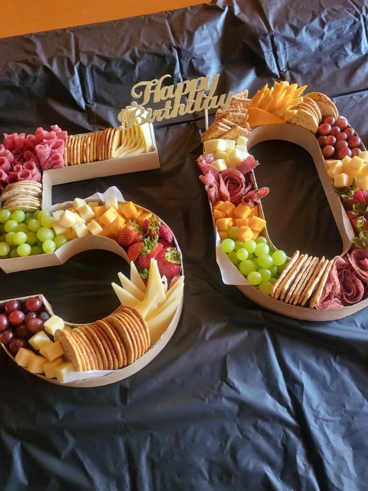 Charcuterie boards shaped into the number 50 filled with meats, cheeses, and fruits.