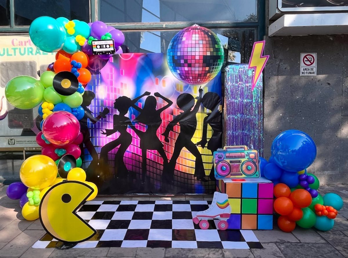 Disco themed party setup with dancer silhouettes, disco ball, boombox, and colorful balloon arches.