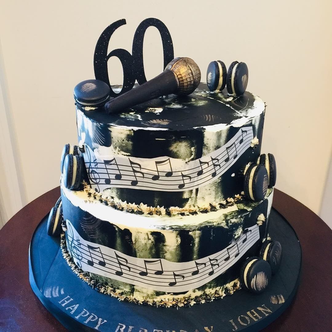 Two-tier black and white musical themed cake with a microphone and number sixty topper.