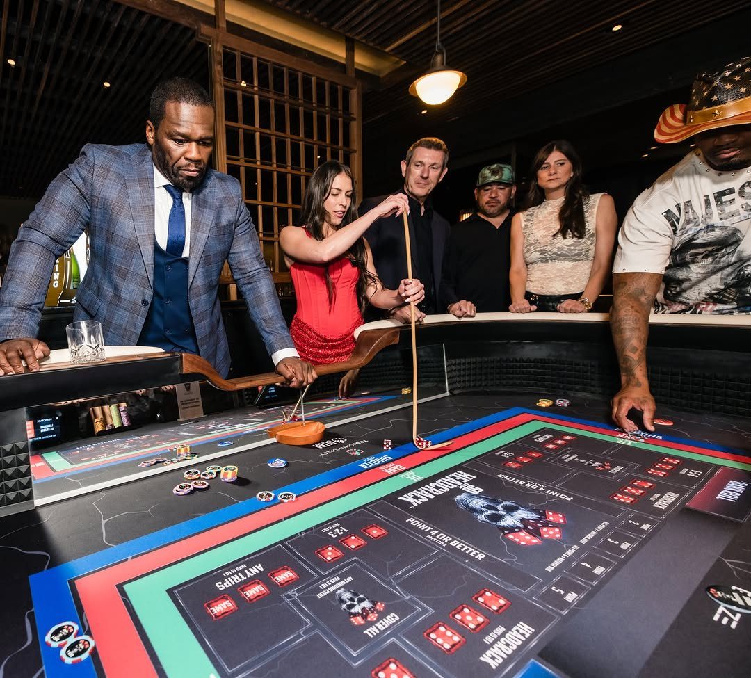 People gathered around a blackjack table with chips and cards in a dimly lit room.