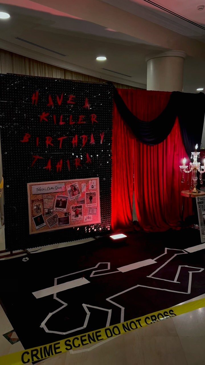 Crime scene themed birthday party setup with red and black decor and yellow caution tape.