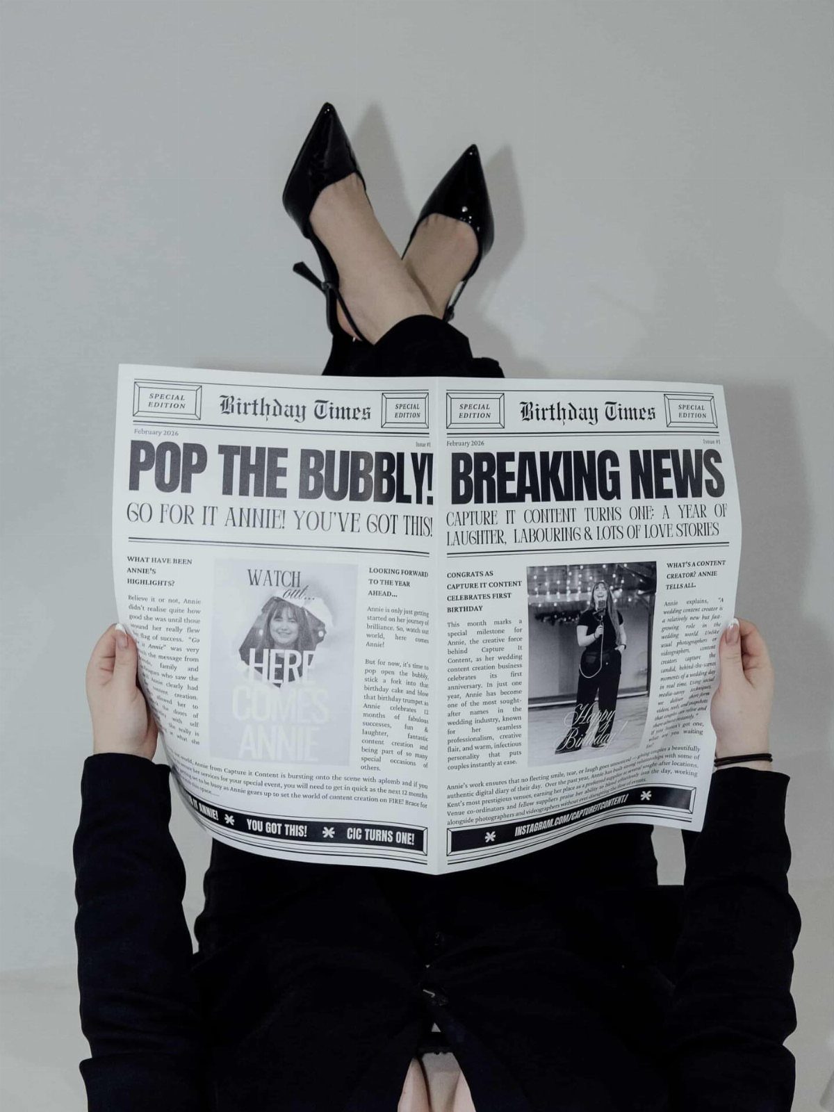 A person holding an open personalized newspaper titled Birthday Times with large celebratory headlines.