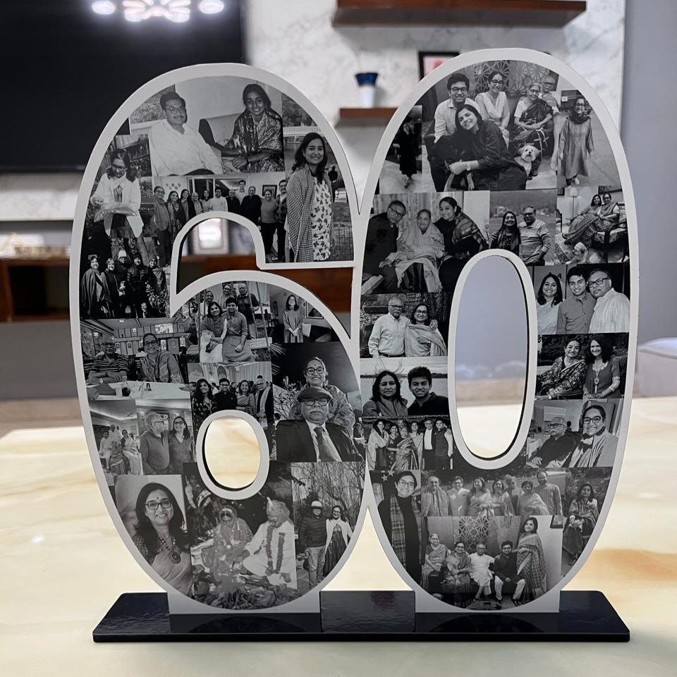 A large number sixty sculpture covered in black and white family photographs on a black base.