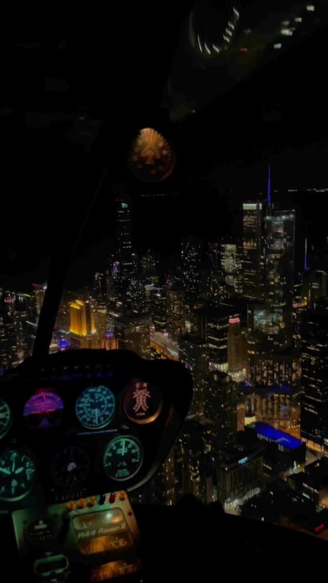 Cockpit instrument panel overlooking a glowing city skyline at night from an aircraft.