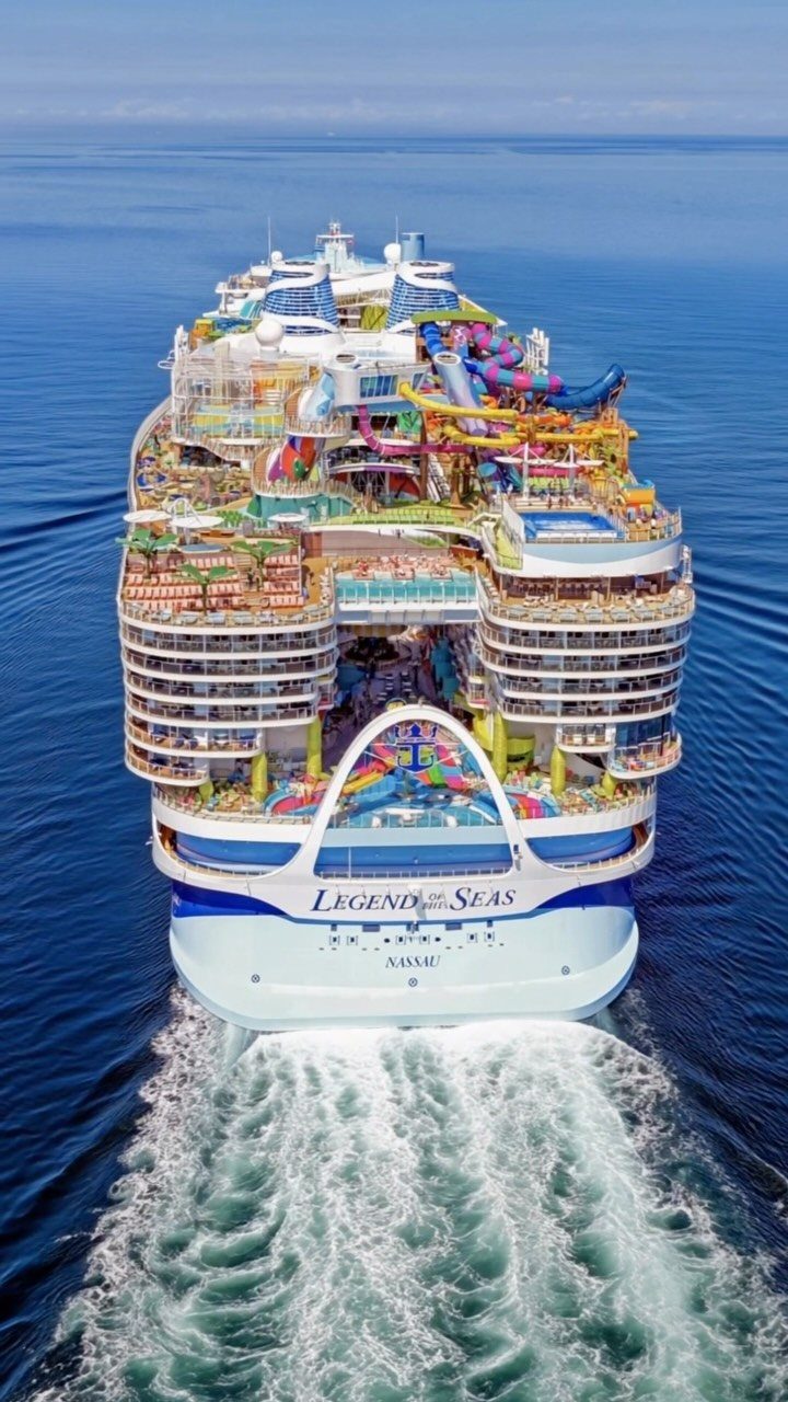 Large cruise ship Legend of the Seas sailing through deep blue ocean water leaving a white wake.