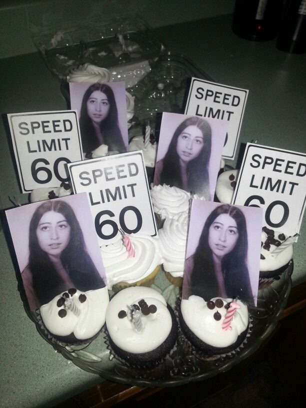 Cupcakes decorated with small portraits of a woman and speed limit signs on a glass plate.