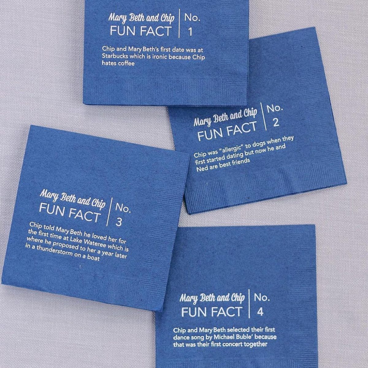 Four blue napkins with white printed fun facts about Mary Beth and Chip.