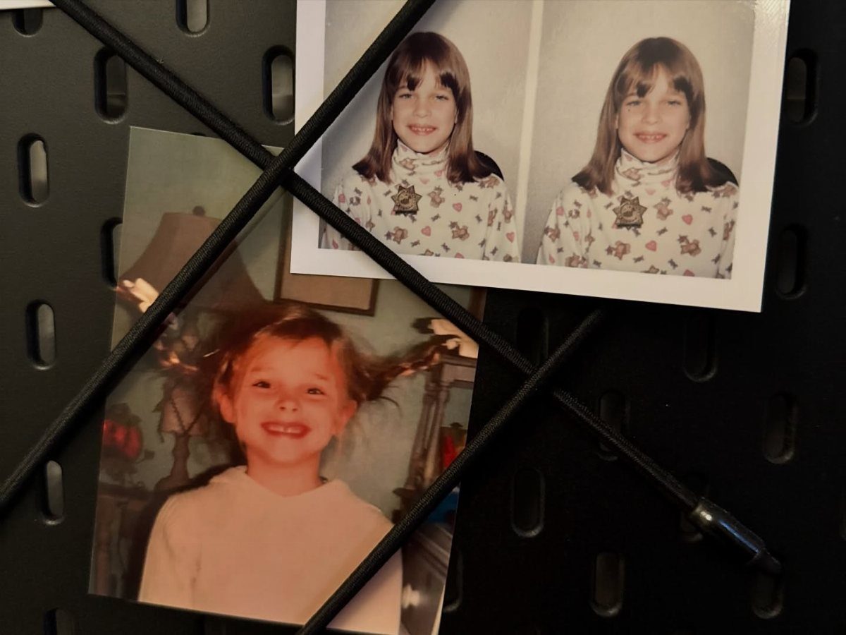 Vintage childhood photographs displayed on a black pegboard with crisscrossing black cords.