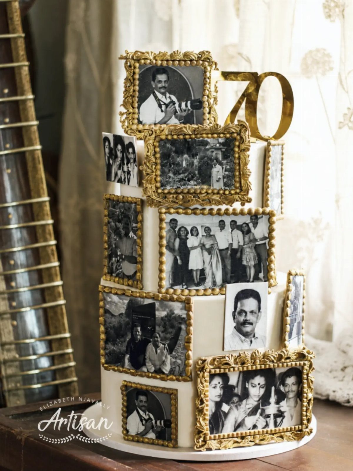Two-tier white cake decorated with edible black and white photos and a gold 70 topper.