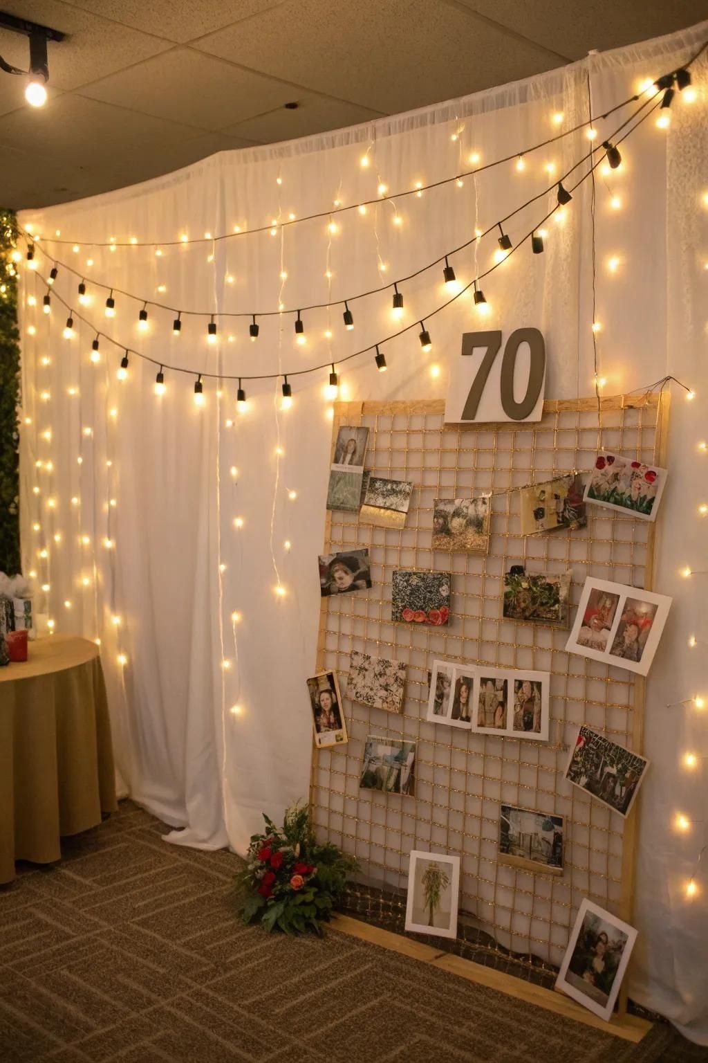 A white backdrop with string lights, a large number 70, and a photo display grid.