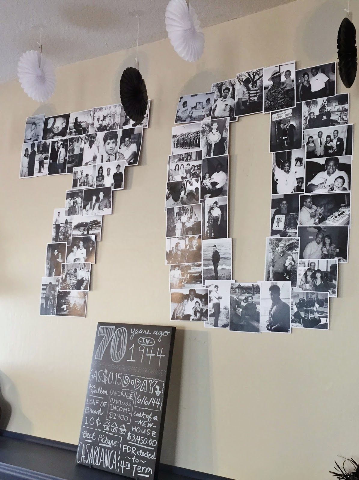Black and white photographs arranged on a wall to form the number seventy above a chalkboard.