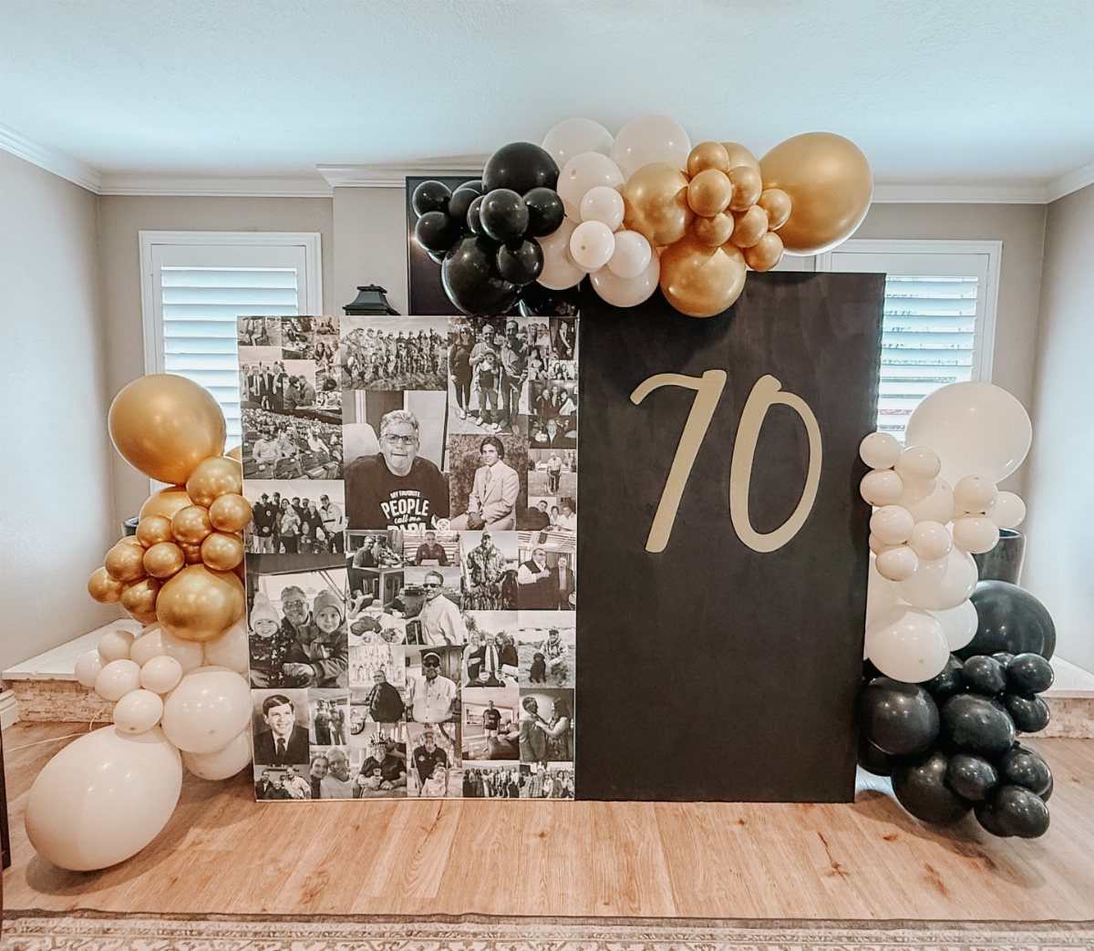 A 70th birthday backdrop with a photo collage and gold number 70 surrounded by balloons.