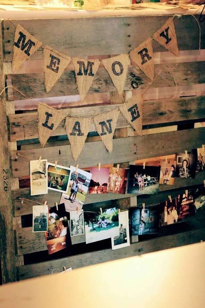 Wooden pallet display featuring burlap bunting and various small photographs clipped to strings.