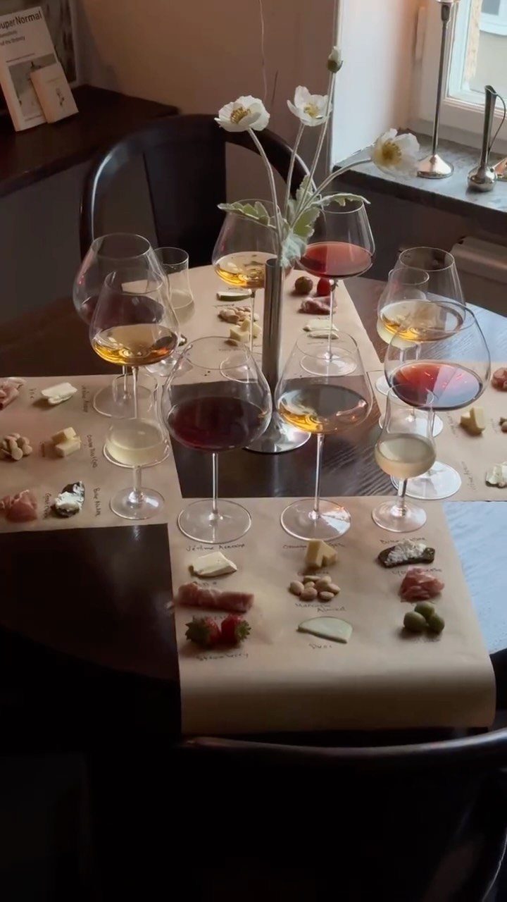 Wine glasses with red and white wine and small appetizers on a wooden table.