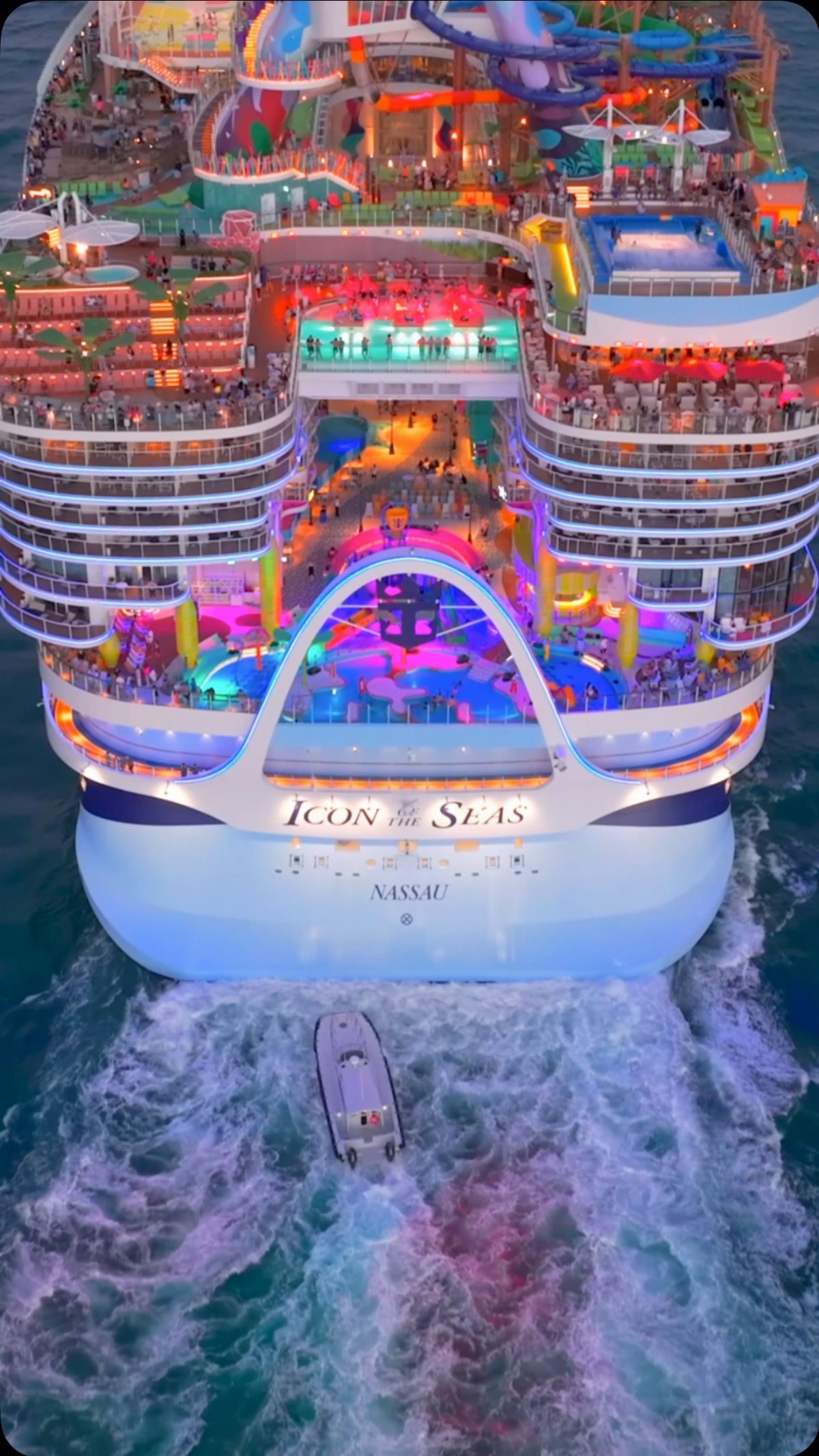 Aerial view of the large Icon of the Seas cruise ship sailing through blue ocean water.