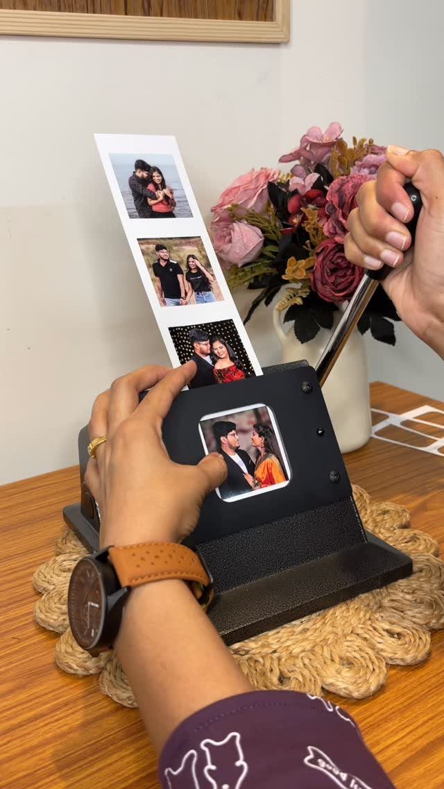 Hands using a knife to cut into a black leather photo frame containing pictures.