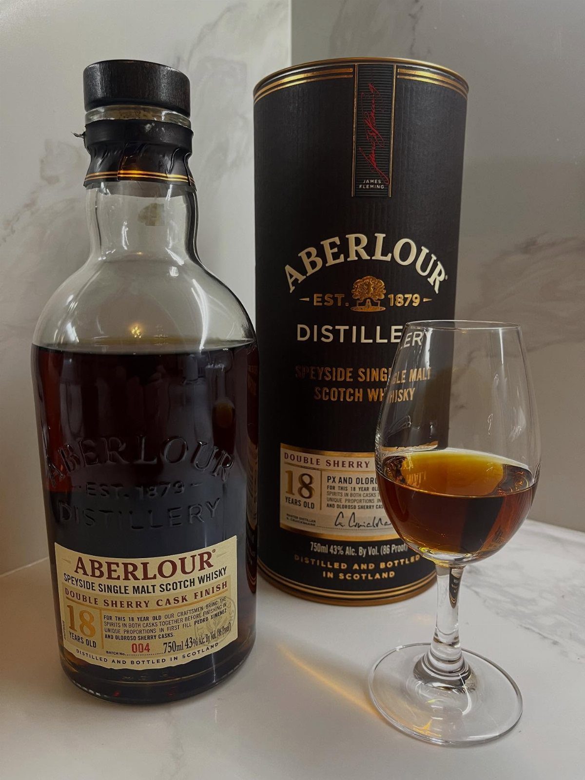 Aberlour 18 Year Old Scotch whisky bottle, presentation tube, and a glass of amber liquid.