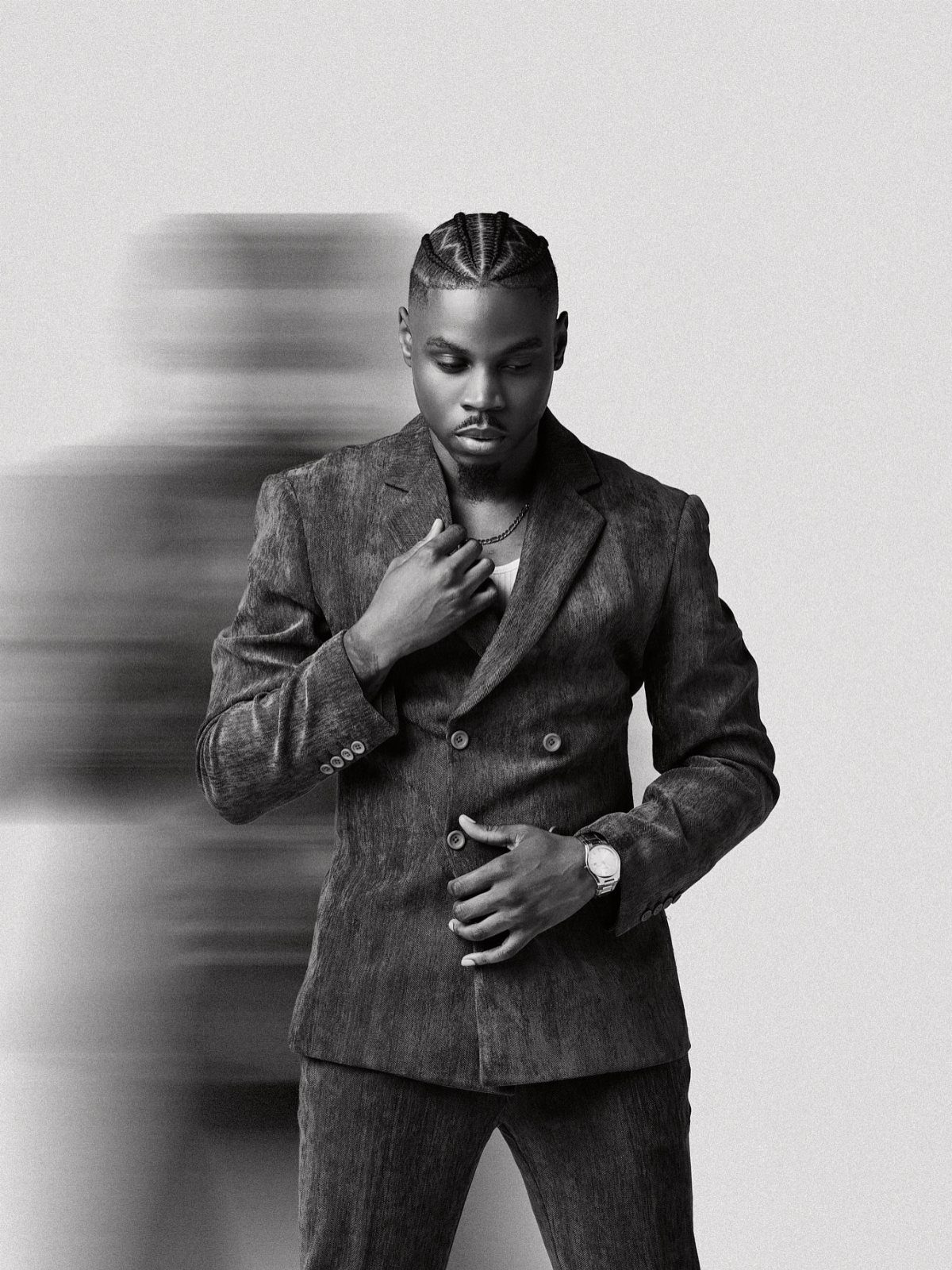 A man in a textured suit posing for a black and white portrait.